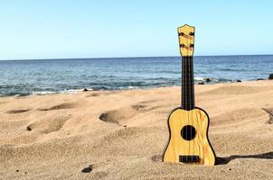 akustisch Gitarre auf das Sand foto