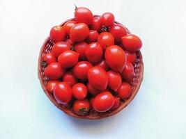 Tomaten in einem Weidenkorb auf einem weißen Hintergrund