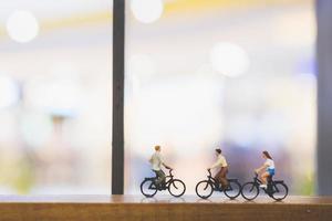 Miniaturreisende mit Fahrrädern auf einer Holzbrücke