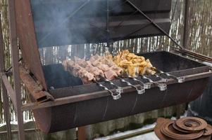 Schaschlik Kebab von anders Typen von Fleisch auf Spieße sind gebraten im das Grill, Rauch von das Feuer foto