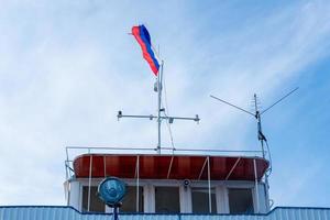 Flagge von Russland Über das Himmel auf das Dach von das Boot foto