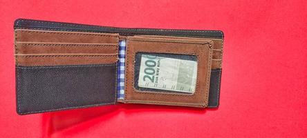 2.000 Rupiah Geld im ein Brieftasche isoliert auf ein rot Hintergrund. foto