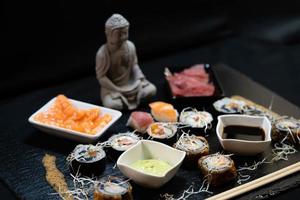 verschiedene arten von asiatischen meeresfrüchten sushi auf einer schiefertafel foto