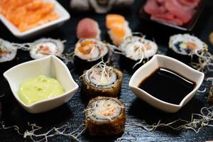 verschiedene arten von asiatischen meeresfrüchten sushi auf einer schiefertafel foto