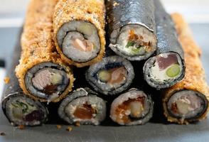 verschiedene arten von asiatischen meeresfrüchten sushi auf einer schiefertafel foto