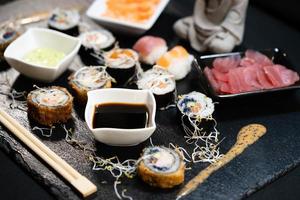 verschiedene arten von asiatischen meeresfrüchten sushi auf einer schiefertafel foto