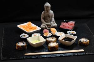 verschiedene arten von asiatischen meeresfrüchten sushi auf einer schiefertafel foto