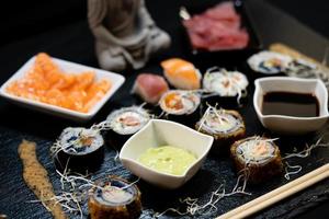 verschiedene arten von asiatischen meeresfrüchten sushi auf einer schiefertafel foto