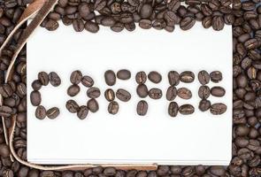 ein Buch mit ein Wörter von Kaffee gemacht durch das geröstet Kaffee Bohnen mit isoliert schwarz Hintergrund. foto