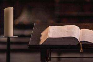 Buch und Kerzen beim das Altar foto