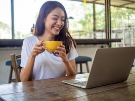 asiatisch Frauen alt 20-30 Jahre alt sind glücklich zu kommunizieren mit fremd freunde über Computers im das Kaffee Geschäft. foto