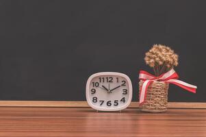 Uhr und Blumentopf auf dem Tisch foto