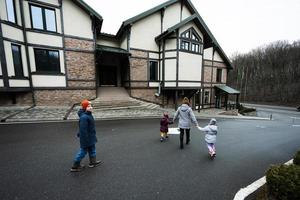 Familie Gehen auf Pfad in der Nähe von hölzern Hütte im das Wald. Land Haus. foto