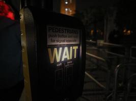 warten Zeichen beim Fußgänger Kreuzung beim Nacht im London foto