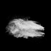 weiße pulverexplosionswolke vor schwarzem hintergrund.weiße staubpartikel spritzen.
