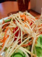 traditionell thailändisch Essen Papaya Salat bereit mit fein Scheiben von Papaya, Tomaten, Grün Bohnen und Erdnüsse, somtum von Thailand foto