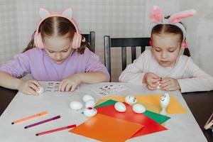 kinder schmücken dummies aus weißen eiern, kleben aufkleber mit verschiedenen emotionen, studieren von emotionen foto