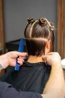 männlich Friseur Schneiden Haar von Frau foto