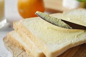 Butter Verbreitung auf ein Brot foto