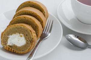 Kaffee Sahne rollen Kuchen mit ein Tasse von Tee auf Tee brechen Zeit foto