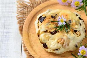 Nussbaum Rosine Brot gefüllt mit Sahne Käse und schmücken mit Blumen und Rosmarin Blätter foto