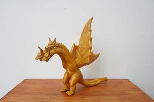 golden Drachen Ghidorah isoliert auf Weiß Hintergrund. auf hölzern Tabelle foto