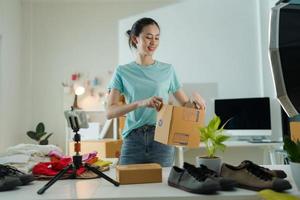 ein jung Frau Inhaber von ein klein E-Commerce Geschäft ist Verpackung Artikel in das Mail Kasten. foto