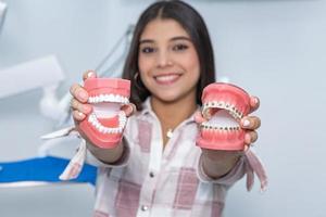 lächelnd ethnisch weiblich Teenager zeigen Zahnersatz im Klinik foto
