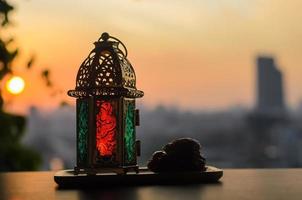 Laterne und Termine Obst mit Dämmerung Himmel und Stadt Hintergrund zum das Muslim Fest von das heilig Monat von Ramadan karem. foto