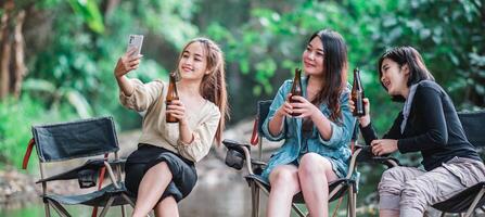 jung Frauen trinken Biere und verwenden Smartphone nehmen Foto