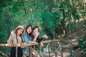 Gruppe junge Frauen, die beim Camping im Wald schöne Natur suchen foto