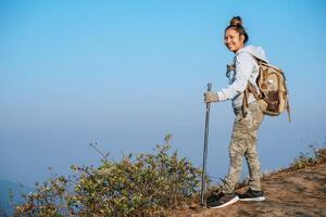 Porträt von glücklich asiatisch Wanderer Frau mit Rucksack suchen beim Kamera auf Berg mit Kopieren Raum foto