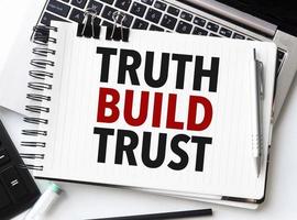 Tastatur von Laptop, Taschenrechner, Bleistift und Notizblock mit Text Wahrheit bauen Vertrauen auf das Weiß Hintergrund foto