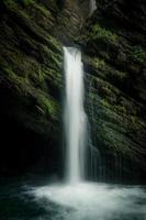 ein mystisch Wasserfall umgeben durch Moos foto