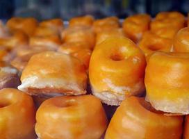 schließen oben selektiv Fokus typisch Dessert Teig im alcala Stil, Rosquillas de Alcala, Puff Gebäck mit Gelb Ei Eigelb Glasur mit Sirup, Ring geformt, Donuts, im Gebäck Geschäft foto