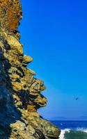 schöne felsen klippen surfer wellen am strand puerto escondido mexiko. foto