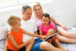 schön lächelnd multiethisch Familie im Vorderseite von das Laptop Video Anruf mit entfernt Eltern beim heim. foto