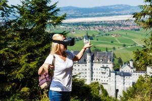 ein Reisender mit virtuell Wirklichkeit Brille. das Konzept von virtuell Reise um das Welt. im das Hintergrund Schloss Neuschwanstein. Zukunft Technologie Konzept. foto