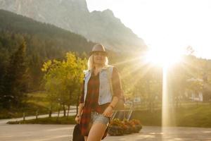 jung Frau im Feld, Natur Hintergrund, Leuchtturm, Hipster Stil, Bohemien Outfit, Denim Jacke, schwarz Hut, lächelnd, Glücklich, Sommer, sonnig, stilvoll Zubehör, Armbänder, Hände foto