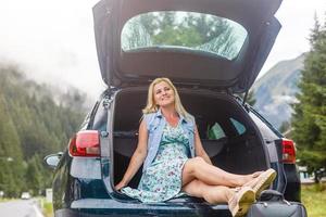 Frau mit Auto in der Nähe von Landschaft Straße durch Berg Alpen foto