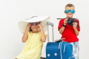 das jung Reisender Kinder mit ein Koffer. isoliert Über Weiß Hintergrund foto