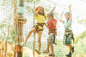 süß Kinder. Junge und Mädchen Klettern im ein Seil Spielplatz Struktur beim Abenteuer Park foto