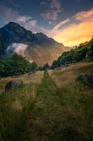 ein Grün Wandern Weg während ein Sonnenuntergang zwischen Berge foto