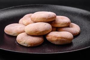 köstlich frisch gebacken Mahlzeit mit Getreide Shortcakes oder Kekse auf ein schwarz Teller foto