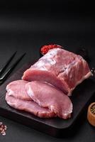 frisch saftig Schweinefleisch auf ein hölzern Schneiden Tafel mit Gewürze und Salz- foto
