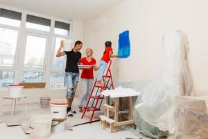 jung glücklich Familie tun Instandsetzung im das Haus zum Verkauf. Konzept von Haus Verkauf. Zuhause Reparatur. foto