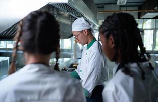 jung Koch, Universität Professor ist Vorbeigehen auf das Wissen von Kochen zu Studenten foto