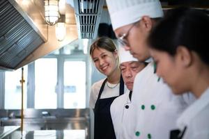 Porträt von ein Gruppe von Köche und kulinarisch Studenten im das kulinarisch Instituts Küche. foto