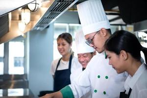 Porträt von ein Gruppe von Köche und kulinarisch Studenten im das kulinarisch Instituts Küche. foto