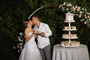 Jungvermählten schneiden glücklich die Hochzeitstorte an und probieren sie foto